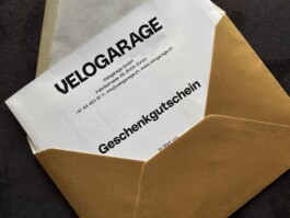Gutschein für die Leistungen und Produkte der Velogarage in einem goldenen Couvert