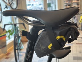 Neue Werkzeugtasche von Apidura mit Magnetverschluss und Rolltop, montiert an einem Rennvelo-Sattel in der Velogarage
