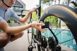 Eine Rennvelofahrerin pumpt ihr Velo mit der E-Pumpe BarBank von BBB